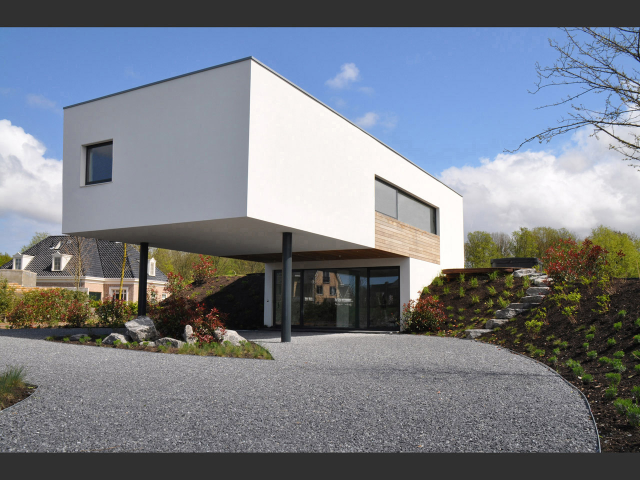 The home is integrated into an existing hill with a rotunda entrance beneath an overhanging projection The home is integrated into an existing hill with a rotunda entrance beneath an overhanging projection