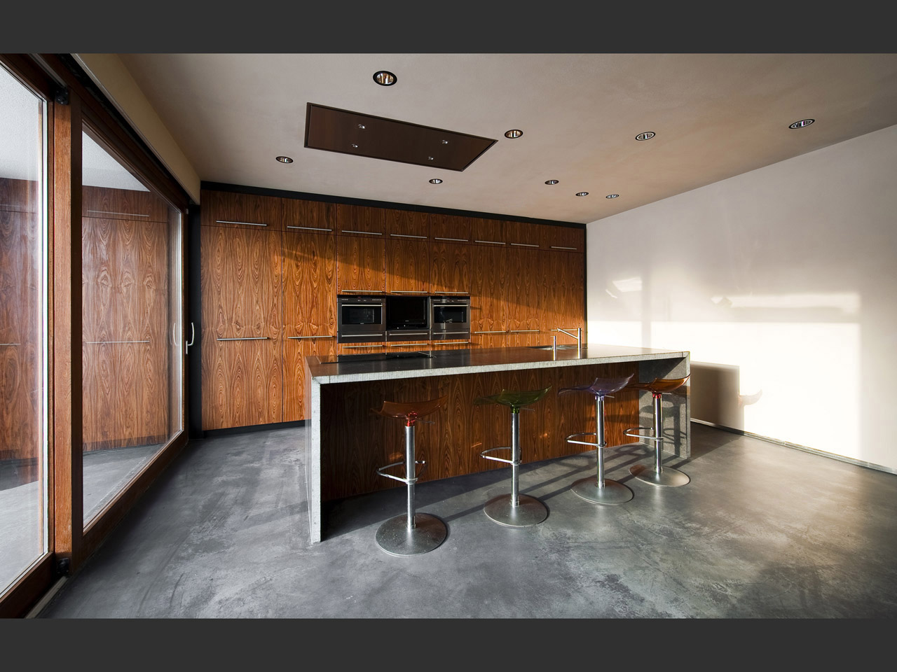 The kitchen walls have a rosewood finishing, giving the room a pure and natural feel.